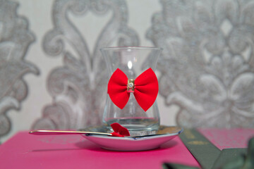 Tea in Azerbaijani traditional armudu pear-shaped glass . Filtered tea for engagement . closed with a red ribbon . check bow tie . Black turkish tea in pear shape glass, aromatic tea in armudu cup .