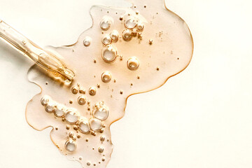 Yellow texture of a drop of whey or olive oil on a white background. Transparent sample of cosmetic gel with bubbles. Golden acid cream. Vitamin c. A drop of honey. Hyaluronic acid. - obrazy, fototapety, plakaty