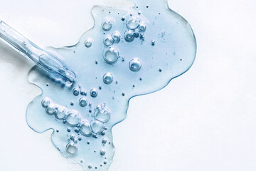 Blue texture of a drop of serum on a white background. Transparent sample of cosmetic gel with...