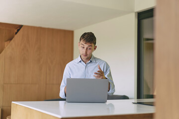 Successful business man working from home with laptop and smartphone