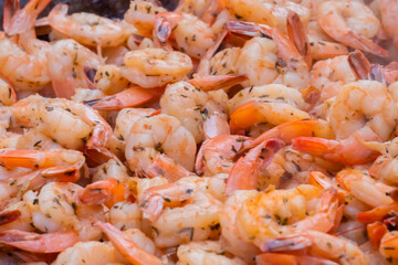 Process of grilling shrimps, prawns on brazier at summer local food market - close up view. Outdoor cooking, gastronomy, seafood, barbecue, street food concept