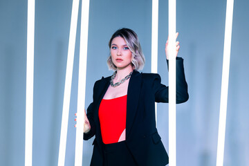 singer posing in the studio. Around the girl neon lamps