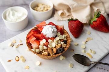 Greek yogurt in ice cream waffle bowl with fruit and nuts, healthy diet friendly dessert. Fruity waffle bowl