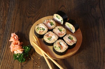 Sushi Set - Different Types of Maki Sushi and Nigiri Sushi. Served on dark wooden table.