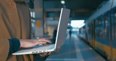 Girl working with laptop at the railway station