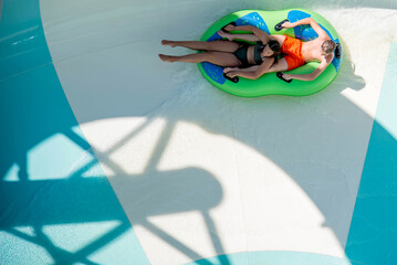 Girl and boy in water Park. Fun on the water. Teen girl and boy having fun in the water slider ....