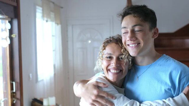 Portrait of grateful teenager man hug smiling middle-aged mother show love and care, thankful happy grown-up son in embrace cheerful mom, enjoy weekend family time at home together, bonding concept

