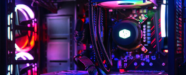 Top-end system unit for gaming computer close up. Inside of illuminated cybercafe. Concept of modern tech, fun, esport, online video games internet cafe