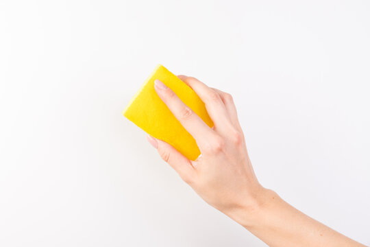 Sponge for washing dishes in female hand. Woman's hand gesture or sign isolated on white. A hand holds a sponge for washing and cleaning dishes
