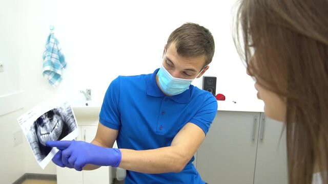 Slow Motion Dentist and female patient looking to x-ray