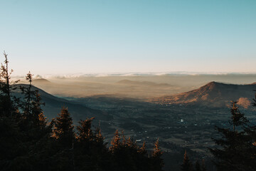 Approaching storm clouds with intersecting sunset and valley view in Beskydy mountains, Czech Republic, Europe. Aerial view to sunbeams falling on mountains and valleys