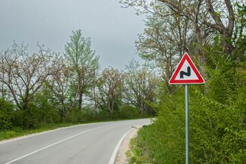 Country road bend and road curve attention traffic sign