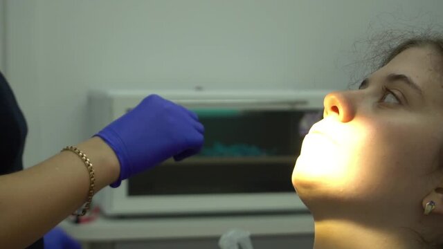 Slow Motion Image of young woman sitting in dental chair at medical center while