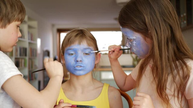 Face painting funny children girls at home making body art to each other