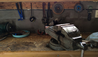 The tools are hanging on the wall in the workshop. Shelf with tools in the barn. Workplace in the workshop.