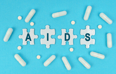 On a blue background, there are pills and puzzles with the inscription - AIDS