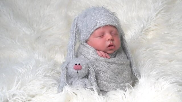 Slow Motion Portrait of a newborn sleeping boy in a hat with ears
