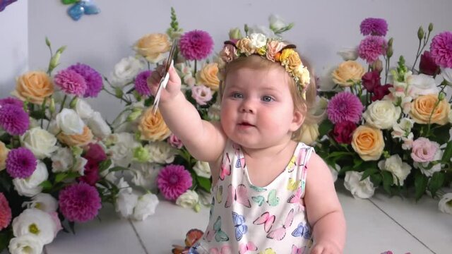 Beautiful baby sitting with a bouquet of flowers