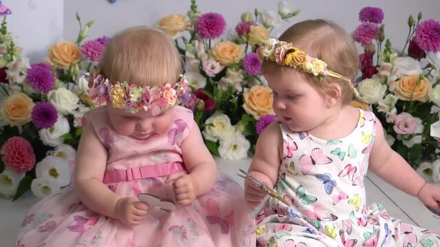 Slow Motion Two little girls in dresses in room with flowers.