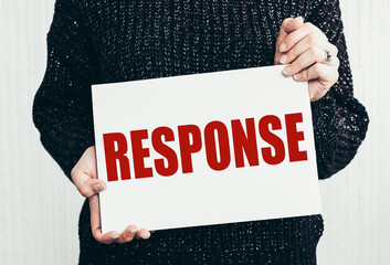 Girl holding a card with text RESPONSE.