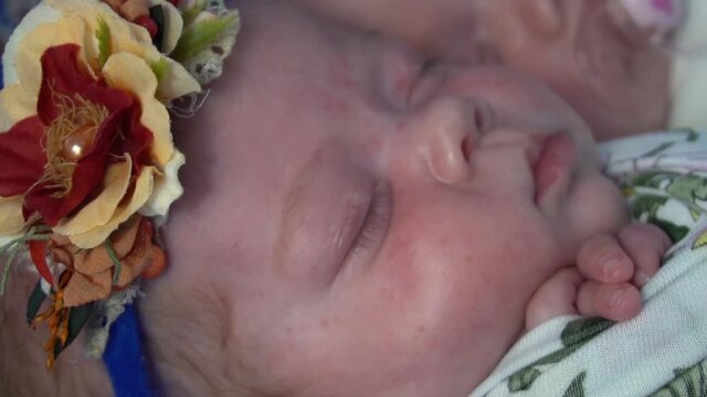 Slow Motion Two adorable newborn twin babies asleep on a soft blanket