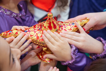 Golden Red Old magic lamp . They touch the old magic lamp with their hands .