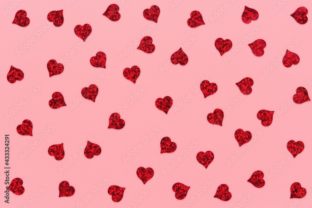 Wall mural red heart shaped confetti pattern on pink abstract background.