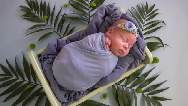 Slow Motion newborn baby. the child in the bed among the leaves.