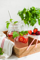 Homemade refreshing strawberry lemonade in pitcher and glass