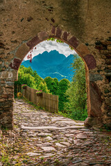Old castle gate with a view of South Tyrolean mountains in Italy.