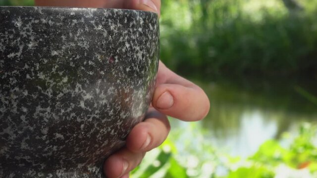 Mix of spices, peppers and sea salt is falling from the grey stone mortar 