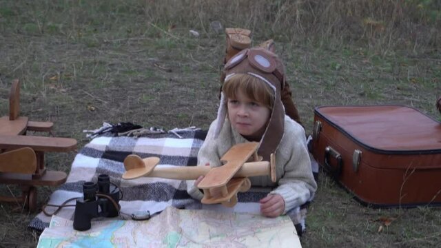 Slow Motion Child pilot aviator with airplane dreams of traveling in nature 