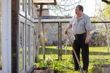 Caucasian Senior man with shovel digging garden bed or farm