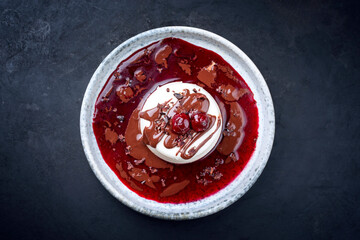 Modern style traditional blancmange almond pudding with cherry, chocolate cream and sour cherry...