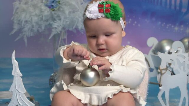 Slow Motion girl sitting on the floor and holding a Christmas ball 