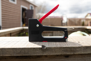 construction stapler on the background of the suburban area. greenhouse renovation and construction...
