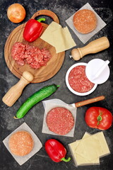Ingredients for Cheeseburger Cooking. Homemade Fast Food for Family Party, Ingredients for Grill And BBQ. Cheeseburger or Sandwich Raw Classic Ingredient On Black Isolated Background, Top View.