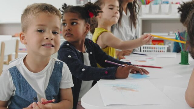 Children smiling and drawing.