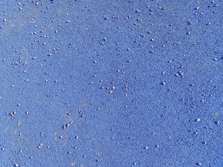 The blue texture of the soft rubber surface of the safe cover of the sports playground for workout made of pressed fine rubber. The background. Texture