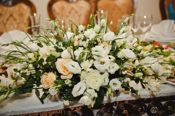 Close-up of a composition of white flowers for a wedding table decoration of the newlyweds