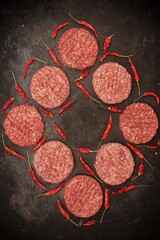 Obraz na płótnie Canvas Many Raw Minced Steak Burgers from Beef Pork Meat on Black Background, Overhead View. Uncooked Ground Meat Patties for Grilling. Burgers for BBQ Grill and Grilling Tools, Top View. Abstract Pattern.