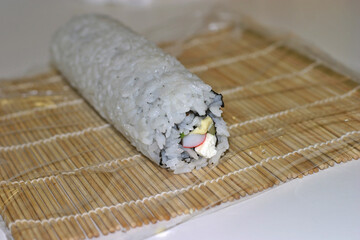Maki sushi roll rolled inside-out ready to be cut