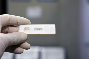 A medical personnel holds a positive pregnancy HCG test on blurred background. Closeup. Human...