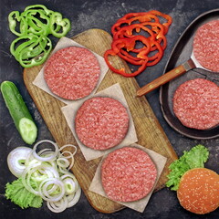 Steak Burgers or Cheeseburger Ingredients  And Cast Iron Grill Pan, Overhead View. Ground Beef Meat Cutlets or Patties on Wooden Chopping Board. Homemade Cooking Food For Family Party, Top View.