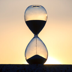 Hourglass against the background of the evening setting sun
