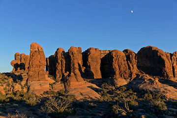 Sandstone formation at sunset with moon visible. Arches National Park, Utah,USA.