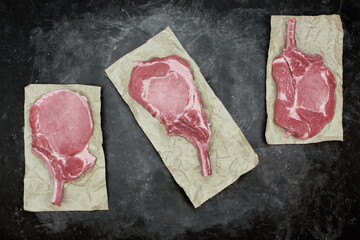 Raw Pork Bone Steaks On Brown Paper. Tomahawk Pork Steaks, Overhead View. Raw Pork Steaks from on...