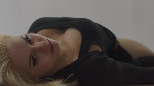 Slow Motion Beautiful sexy blonde woman lying, looking at camera.