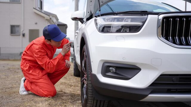 自動車のタイヤを点検する男性整備員