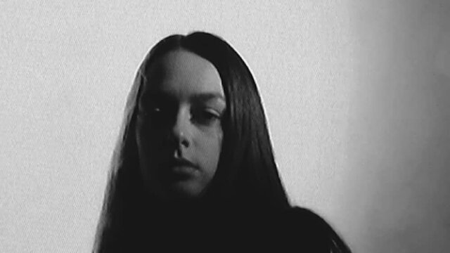 Mental disorder. Real analog video. VHS glitch noise. Loneliness depression. Apathetic disturbed woman face in black in smoke cloud with flicker distortion.